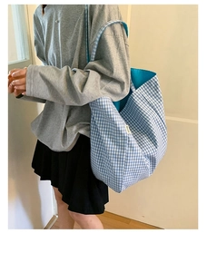 Detail view of large blue and white checkered canvas tote bag with inner lining and brand label