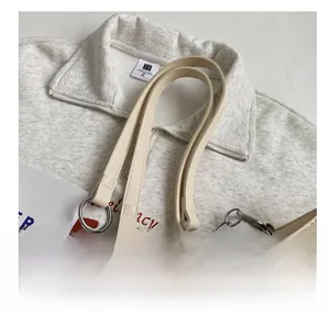 Detail of light beige straw tote bag with smooth PU leather handle and silver metal rings