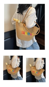 Detail view of woven beach tote bag with summer embroidery and stylish orange handles