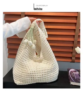 Detail of white crochet shoulder bag with hollow mesh pattern and tulip charm