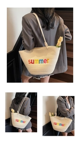Close-up of beige woven beach tote bag featuring rainbow summer embroidery and shoulder strap
