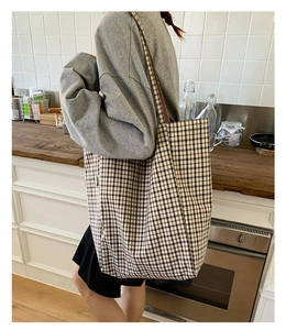 Detail shot of large canvas tote bag featuring classic black and beige checkerboard pattern
