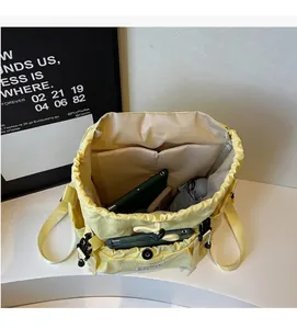 Internal view of a spacious beige nylon backpack showing storage for tablets and umbrellas