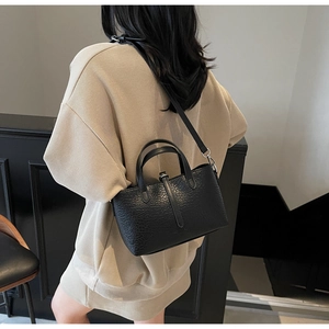 Crocodile pattern black crossbody bucket bag shown on model with beige knitwear set