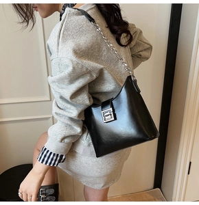 Détail du sac sous l'aisselle noir minimaliste avec boucle argentée et bandoulière