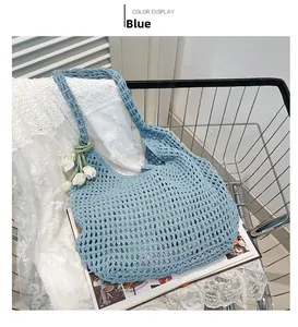 Detail of light blue hollow crochet beach bag with white tulip charm decoration