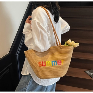 Detail of colorful summer embroidery on khaki woven tote bag with brown straps