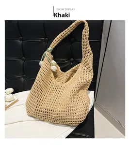 Detail of khaki woven straw bag with mesh crochet pattern and white tulip charm