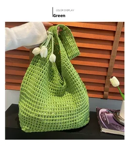 Green knit tote bag detail featuring woven texture and white tulip charms on a strap