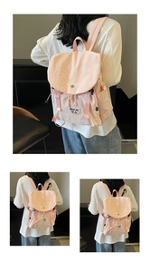 Close-up of pink nylon backpack with drawstring closure and white woven brand label