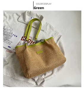 Detail of green leather handle with silver chain on the straw woven tote bag