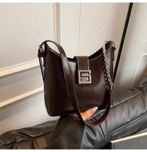 Détail du sac sous l'aisselle en cuir marron foncé avec boucle argentée et chaîne