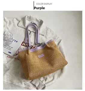 Straw tote bag detail with light purple leather handles and silver metal ring accents