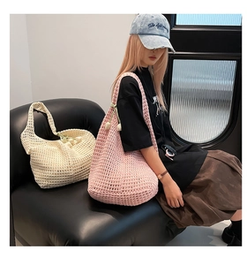 Detail of hollow-out knit tote bag with 3D floral charm in pink and beige shades