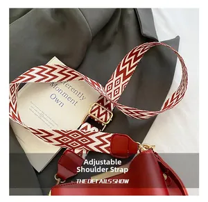 Close-up of red leather bucket bag with a geometric pattern woven adjustable shoulder strap