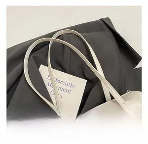 Close-up of soft white leather underarm bag featuring elegant pleated texture and ruffles