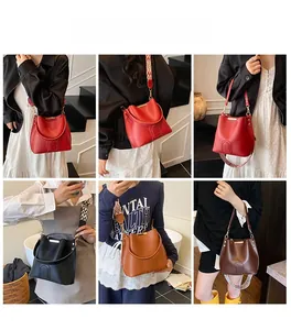 Detail view of stylish bucket bags in red, black, and brown with patterned wide straps