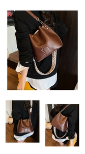 Detail of dark brown leather bucket bag with jacquard woven strap and gold hardware