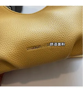 Detailed macro view of yellow lychee grain leather with FASHION & BAGS logo embossing