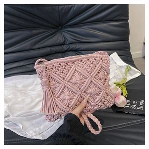 Detailed close-up of pink woven cotton fringe clutch with bohemian geometric texture