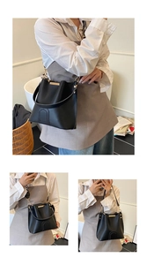 Detail view of black leather bucket bag with gold hardware and woven print strap