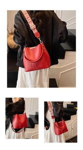 Detail of red bucket bag showing smooth leather texture and wavy patterned woven strap