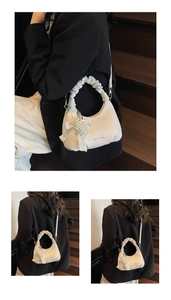 Detail of white leather mini bag with pearl heart charm and ruffled handle