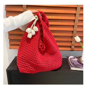 Detailed close-up of red crochet knit tote bag featuring white tulip floral accessory
