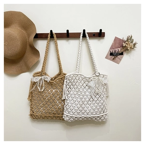 Detailed close-up of handmade woven summer tote bags with lace bows and pearl charms