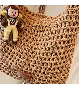 Detail of khaki woven cotton rope texture with a cute doll charm and pearl chain