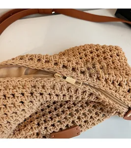 Detail of smooth gold metal zipper and inner lining of the woven cotton bucket bag