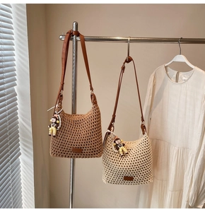 Close-up of hollow cotton weave bucket bag with leather strap and cute charm detail