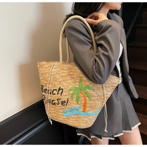 Detail of hand-woven straw tote bag with palm tree embroidery and Beach Please text