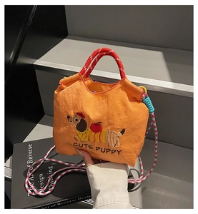 Detail of orange bucket bag with cute dachshund embroidery and colorful woven straps