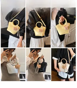 Quattro borse a secchiello in giallo, argento, nero e beige con ciondoli a forma di orso