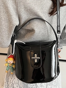 Borsa a secchiello in vernice nera con chiusura argentata e ciondolo a forma di bambola