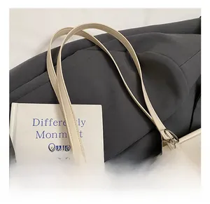 Detail of minimalist cream tote bag showing leather strap and Moduola brand label