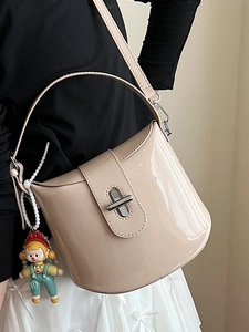Borsa a secchiello minimalista in vernice beige con chiusura in metallo e ciondolo