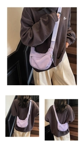 Detail of light purple nylon crescent bag featuring multiple zippers and adjustable wide strap