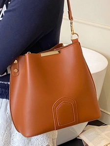 Brown vintage leather bucket bag with adjustable shoulder strap and gold metal hardware