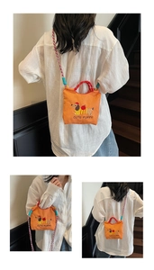 Detail of orange canvas bucket bag with cute dachshund embroidery and woven strap