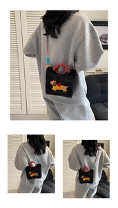 Detail of black canvas bucket bag with cute dachshund embroidery and colorful woven strap