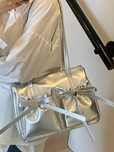 Silver Y2K shoulder bag with decorative bows and pleated front pockets for women