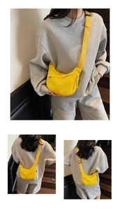 Detailed view of yellow minimalist crossbody crescent bag with functional zip pockets