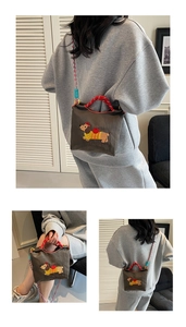 Detail view of the embroidered dachshund dog pattern on the brown canvas mini bucket bag