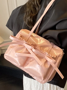 Pink glossy patent leather shoulder bag with decorative bows and stylish ruffles