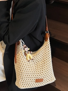 Summer 2025 beige woven bucket bag with brown leather straps and cute doll pendant