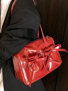Chic red bow shoulder bag in glossy patent leather finish for stylish daily commuting