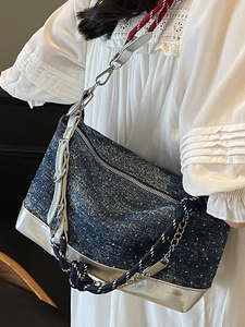 Deep blue denim underarm bag with white polka dots and metallic silver trim details