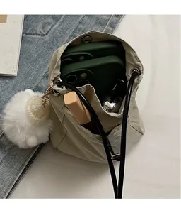 Interior view of beige drawstring bucket bag showing storage space for phones and makeup